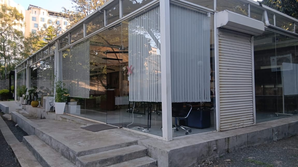 The glass-fronted Hocan Holdings office building surrounded by greenery